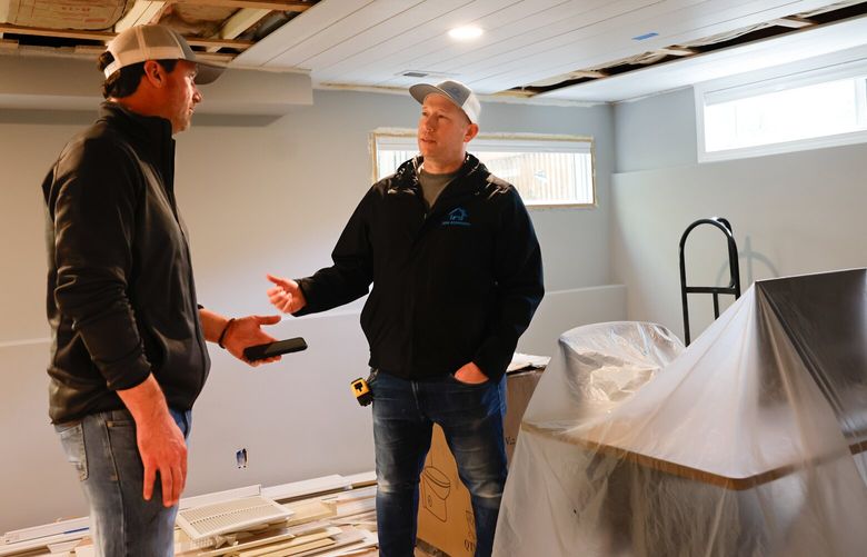 Justin Schuder, left, a contractor, and Ryan Keene, a project lead, both from J & M Remodel work on a project remodeling a basement in a home in West Seattle on Tuesday, April 8, 2025.