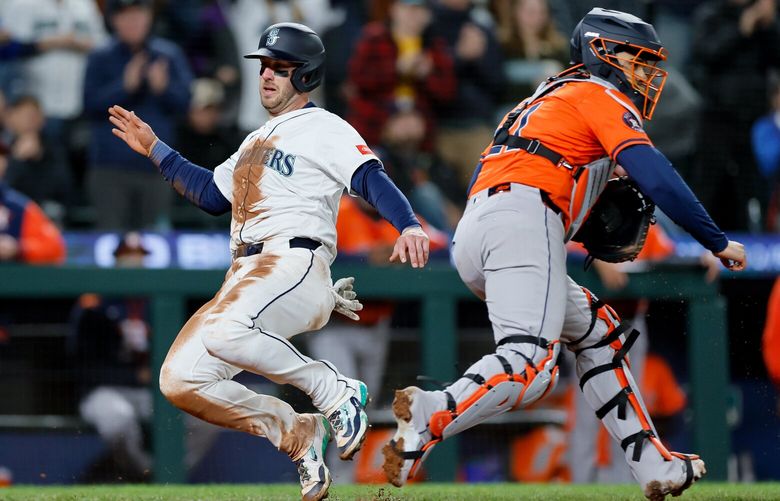 Seattle’s Mitch Garver slides past Houston Astros catcher Yainer Diaz for the game-tying run during the seventh inning Tuesday, April 8, 2025 in Seattle. 229708