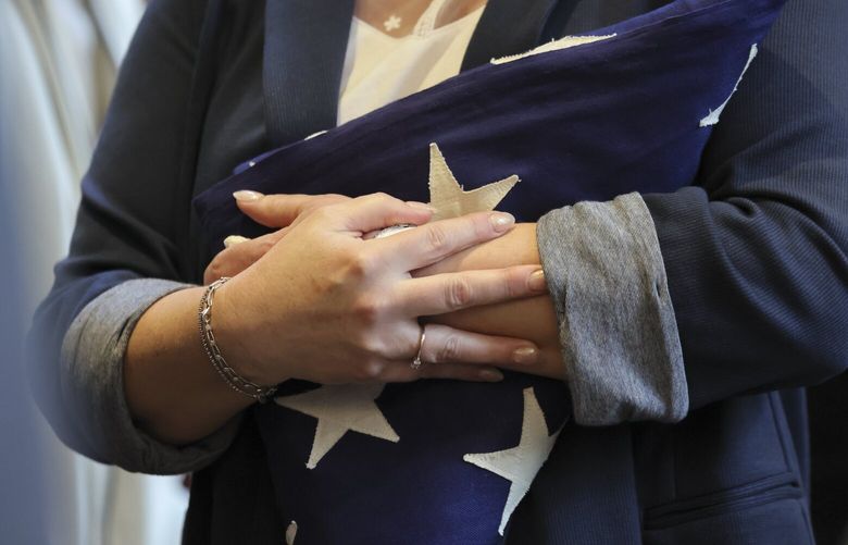 April Van Brundt holds the memorial flag after the ceremony to add Bryan Van Brunt’s name to the “In the Line of Duty” wall Friday morning at Seattle Police Department headquarters in Seattle, Washington, on April 11, 2025. 229763