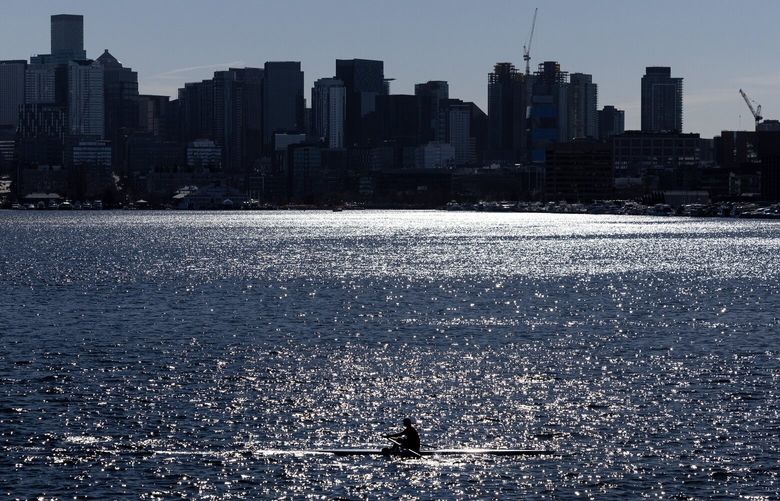 A rower glides across Lake Union as the sun shimmers on the water on Thursday, Feb. 27, 2025, in Seattle.