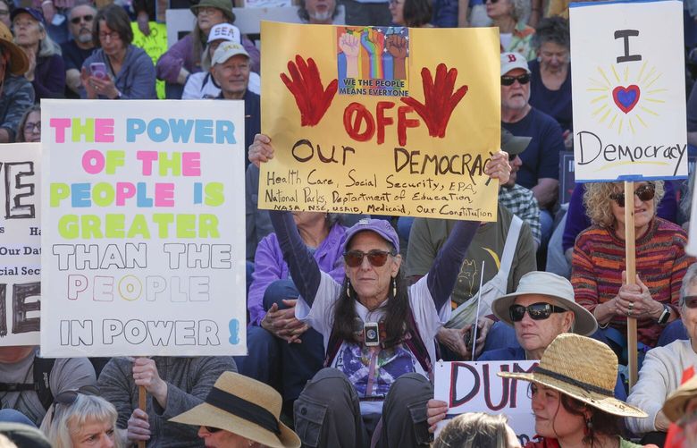 People show pickett signs for a “Remove, Reverse, Reclaim” and “Hands Off!” demonstration on the steps Washington State Capitol in Olympia on Saturday, April 5, 2025. Protesters opposed the Trump administration’s actions and Elon Musk’s government involvement.