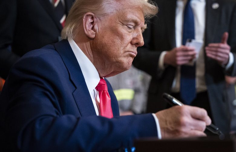President Donald Trump signs executive orders. MUST CREDIT: Jabin Botsford/The Washington Post