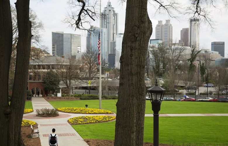 FILE – A person walks through the Georgia Tech campus with the downtown skyline in the background, March 11, 2016, in Atlanta. (AP Photo/David Goldman, File) NYRL106 NYRL106