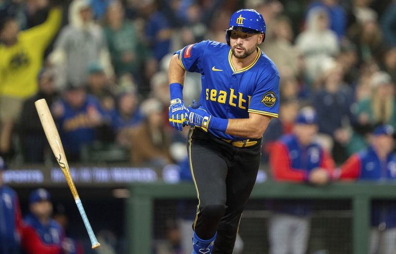 Seattle Mariners’ Cal Raleigh tosses his bat after hitting a two-run home run during the eighth inning of a baseball game against the Texas Rangers, Friday, April 11, 2025, in Seattle.
