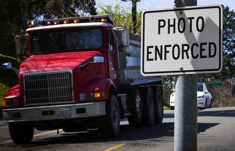 Traffic moves past a speed camera warning sign near Dearborn Park International Elementary School, Tuesday, April, 15, 2025, in Seattle’s Beacon Hill neighborhood. SDOT is doubling the number of school locations that have automatic speed cameras this year, from 19 to 38, as well as determining where to put speed cameras outside of school zones.