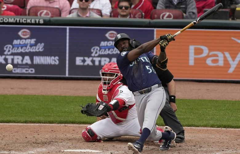 Seattle Mariners’ Randy Arozarena, front right, hits a double, scoring Miles Mastrobuoni and Julio Rodríguez in the 10th inning of a baseball game against the Cincinnati Reds, Thursday, April 17, 2025, in Cincinnati. 