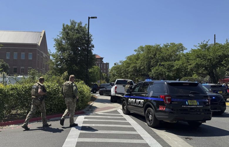 Dozens of patrol vehicles, including a forensics van, are stationed outside of Florida State University’s student union building, the scene of a shooting, Thursday, April 17, 2025, in Tallahassee, Fla. (AP Photo/Kate Payne) RPKP405 RPKP405