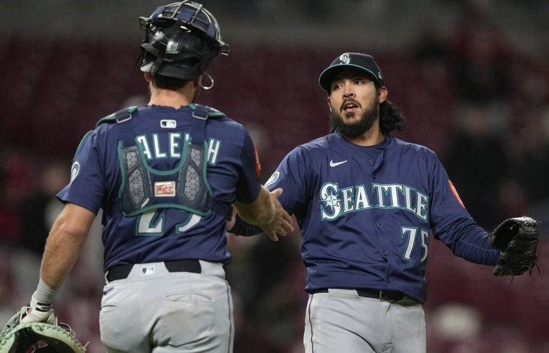 Seattle Mariners pitcher Andrés Muñoz, right, celebrates with catcher Cal Raleigh after winning of a baseball game against the Cincinnati Reds, Wednesday, April 16, 2025, in Cincinnati. (AP Photo/Carolyn Kaster) OHCK115 OHCK115