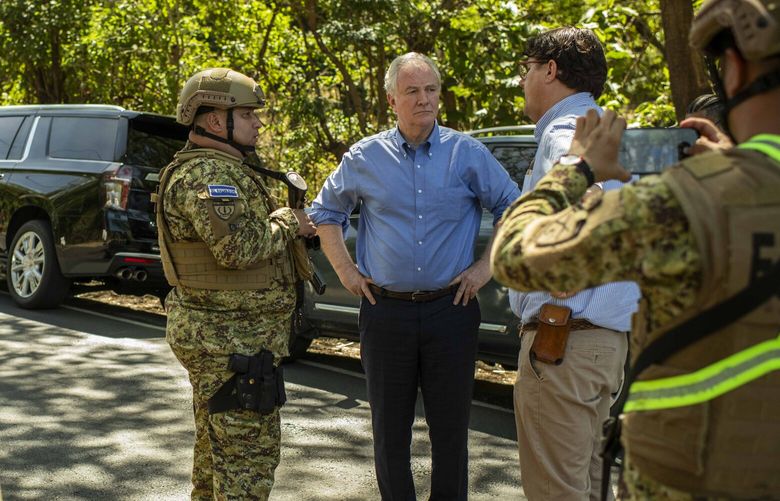 Sen. Chris Van Hollen (D-Md.), third from right, and Chris Newman, a lawyer with the family of Kilmar Armando Abrego Garcia, speak with a soldier at a military checkpoint about a mile away from the notorious Salvadorian prison known as CECOT in El Salvador, on Thursday, April 17, 2025. A U.S. senator was denied entry to a prison holding Kilmar Armando Abrego Garcia and other deportees. (Daniele Volpe/The New York Times) XNYT0801 XNYT0801