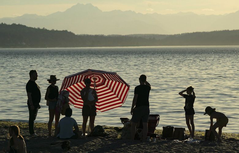 FILE — People at Alki Beach as the sun sinks near the end of the day, bringing some relief from the heat, in Seattle, June 24, 2021. The forecast for the coming week suggests there will be few places in the continental United States to find relief. (Ruth Fremson/The New York Times)