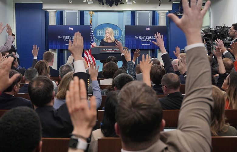 Journalists raise their hands to ask questions as White House press secretary Karoline Leavitt speaks with reporters in the James Brady Press Briefing Room at the White House, Tuesday, April 15, 2025, in Washington. (AP Photo/Alex Brandon) DCJE315 DCJE315