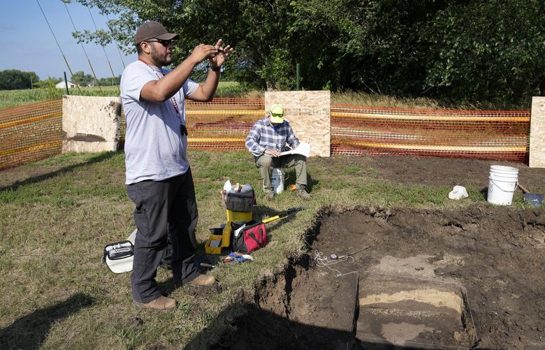 FILE – Omaha Tribe member Mark Parker, of Macy, Neb., takes a photo as workers dig for the suspected remains of children who once attended the Genoa Indian Industrial School, July 11, 2023, in Genoa, Neb. (AP Photo/Charlie Neibergall, File) NYAB502 NYAB502