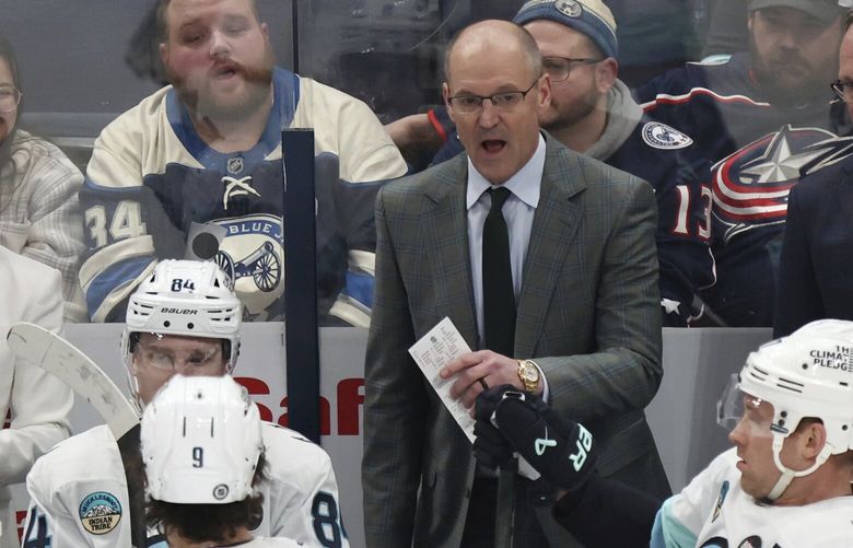 Seattle Kraken coach Dan Bylsma, center top, talks to members of his team during the third period of an NHL hockey game against the Columbus Blue Jackets in Columbus, Ohio, Thursday, Jan. 9, 2025. (AP Photo/Paul Vernon)