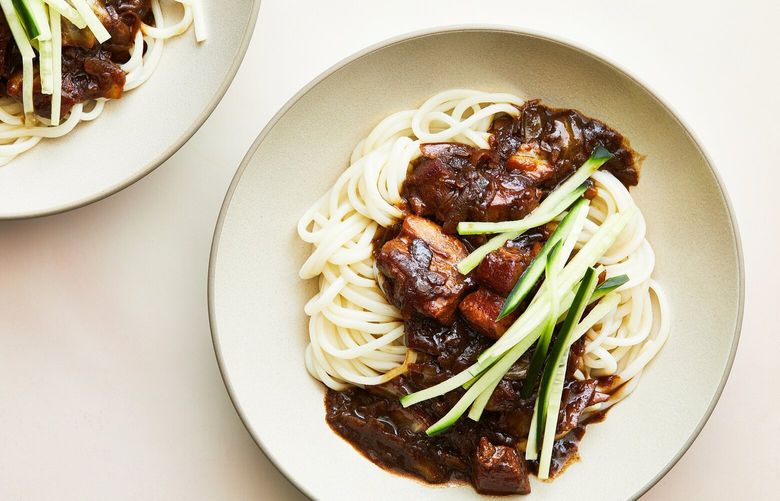 Jjajangmyeon (black bean noodles). Smothered in a supersavory gravy studded with pork belly, these chewy wheat noodles are South Korea’s cultural equivalent to delivery pizza in the United States. Food styled by Simon Andrews. (Armando Rafael/The New York Times)