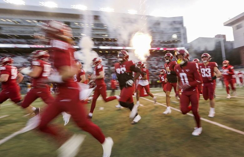 Washington State players run onto the field before an NCAA college football game against Wyoming, Saturday, Nov. 30, 2024, in Pullman, Wash.