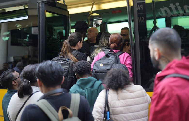 People try to board a crowded bus after the subway stopped running following a power outage in Lisbon, Portugal, Monday, April 28, 2025. (AP Photo/Armando Franca) BGK101 BGK101