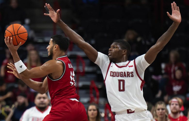 Eastern Washington guard Nic McClain (11) makes a pass as Washington State guard Cedric Coward (0) defends during the second half of a NCAA college basketball game, Thursday, Nov. 21, 2024, at the Spokane Veterans Arena.
