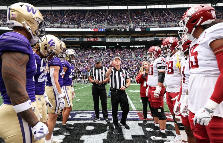 The refereee tosses the coin to determine posession at the start of Saturday’s game.  The Washington Huskies played the Washington State Cougars in the 116th edition of the Apple Cup game Saturday, Sept. 14, 2024 at Lumen Field, in Seattle, WA. 228030