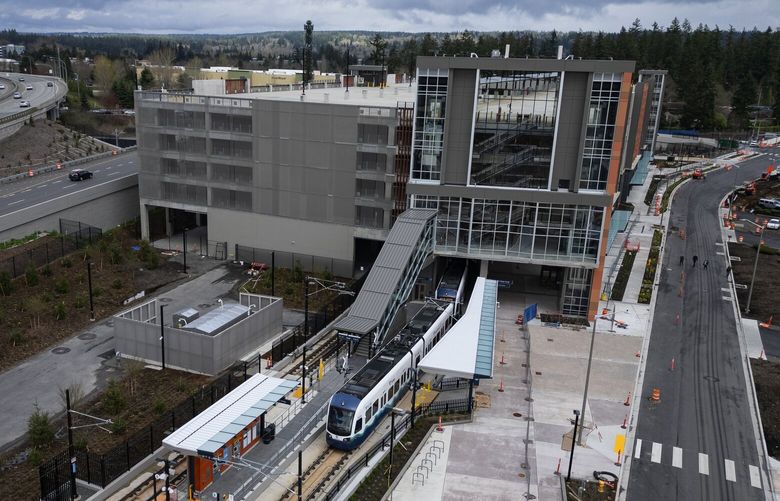 A light rail train being tested enters the 1400-stall Marymoor Village Station parking garage before popping out another side and continuing on to the 2 Line’s terminus in downtown Redmond, seen from the air, Tuesday, April 1, 2025, in Redmond.