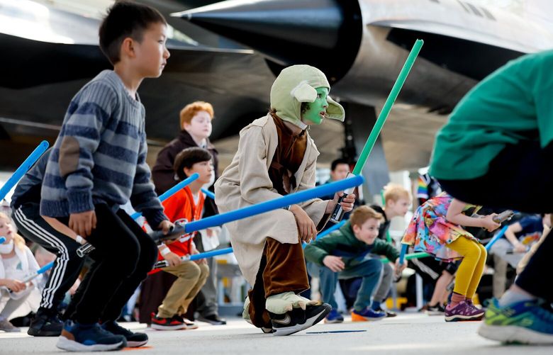 In the shadow of a Lockheed SR-71 Blackbird, eight-year-old Remi Lusby, center, dressed as Yoda, crouches with the rest of his class of younglings during a Saber Guild lightsaber training during a May the 4th event at the Museum of Flight Sunday, May 4, 2025 in Seattle.

Remi just missed taking part in the training last year by one kid, so this year, he and his mom came early to sign up to ensure that Remi wouldn’t miss the fun.

This is the second year that the Museum of Flight has held a May the 4th specific Star Wars event. About ____ kids and adults attend this year’s galactic celebration featuring lightsaber training, live music, face painting, LEGO displays, a costume contest and more. The Museum of Flight intends to hold another May the 4th event next year. 229872