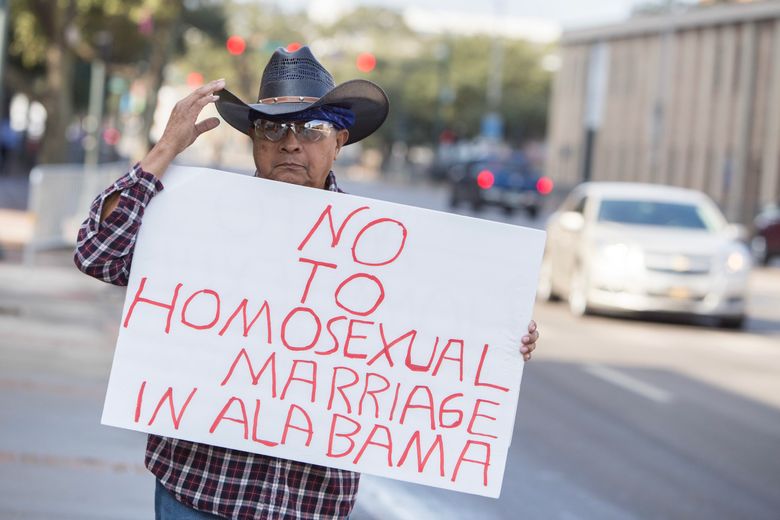 FILE — A man stands alone outside the county courthouse in Mobile, Ala., to protest the issuing of gay marriage licenses on Feb. 9, 2015. Red-state efforts to urge the Supreme Court to reconsider same-sex marriage have not advanced, but in 2025, they have reopened the issue. (Jeff Haller/The New York Times)