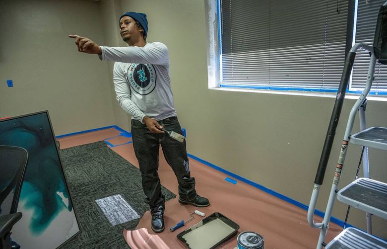Sidney Randle gives instruction to an apprentice while he was painting at the People Working Together training facility in Sacramento. (Renée C. Byer/The Sacramento Bee via TNS)