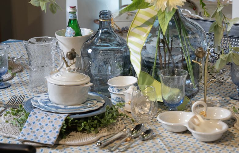 Transform your table with a subtle, geometric-patterned, block-printed tablecloth. Pair it with matching napkins and blue and white chinoiserie-inspired plates, complemented by crisp white dinnerware. Add green florals, such as daisies, arranged in blue-tinted glass vessels that match the blue-hued glassware. (TNS)