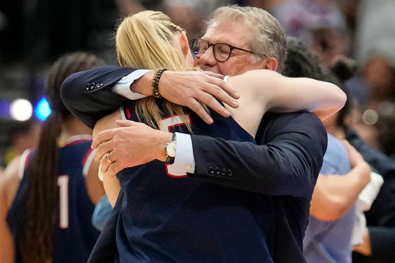 UConn head coach Geno Auriemma hugs UConn guard Paige Bueckers (5) as she comes off the floor late in the second half of the national championship game against South Carolina at the Final Four of the women’s NCAA college basketball tournament, Sunday, April 6, 2025, in Tampa, Fla. (AP Photo/Chris O’Meara)