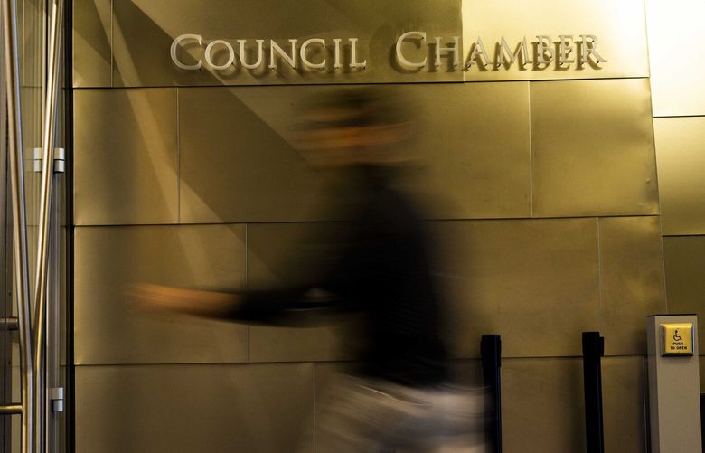 An attendee shuffles into city council chambers before the meeting on Tuesday, Jan. 24, 2023.