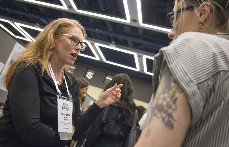 Dr. Sara Jane Webb, left, who is a developmental cognitive neuroscientist with Seattle Children’s Research Institute, speaks with Dr. Bri Cairney, right, who is a postdoctoral associate in the Yale Child Study Center and originally from the Pacific Northwest, about her research presentation during the Society for Autism Research’s annual meeting held at the Seattle Convention Center in downtown Seattle this year, on Thursday, May 1, 2025.  229915 (Ivy Ceballo / The Seattle Times)