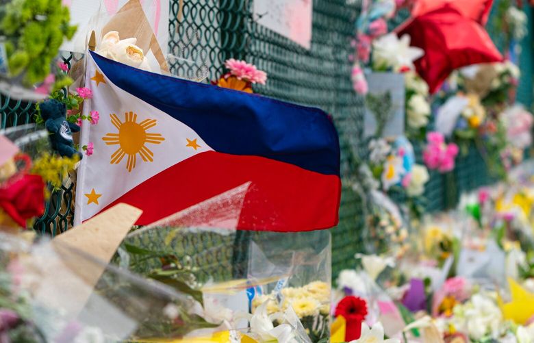 A Philippines flag waves in the wind at a memorial site for the victims of an incident where a car drove through a crowd killing multiple people in Vancouver, British Columbia, Monday, April 28, 2025. (Rich Lam/The Canadian Press via AP) RXL113 RXL113