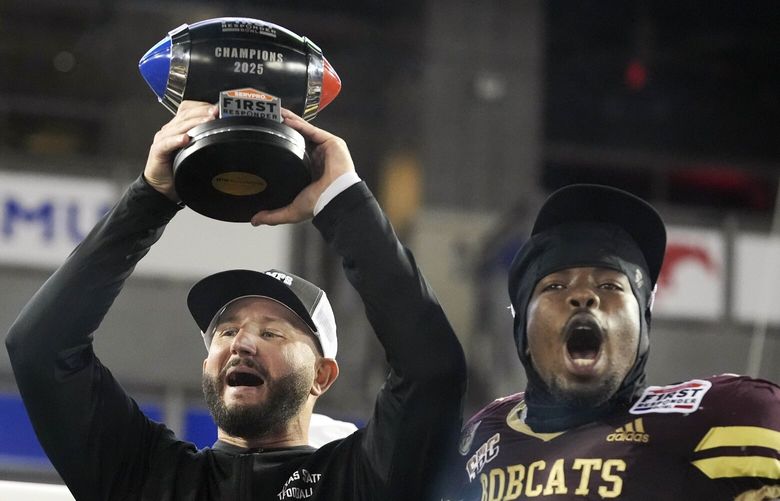 Texas State head coach GJ Kinne lifts the winner’s trophy with defensive end Kalil Alexander (22) after the First Responder Bowl NCAA college football game against North Texas Friday, Jan. 3, 2025, in Dallas.