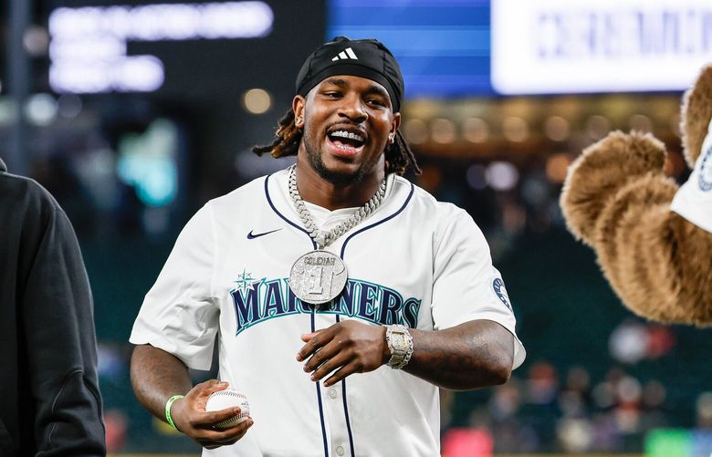 Washington quarterback Demond Williams, left, accompanies running back Jonah Coleman to the mound for Tuesday night’s ceremonial first pitch at T-Mobile Park. The Los Angeles Angels played the Seattle Mariners in Major League Baseball Tuesday, April 29, 2025 at T-Mobile Park, in Seattle, WA. 229850