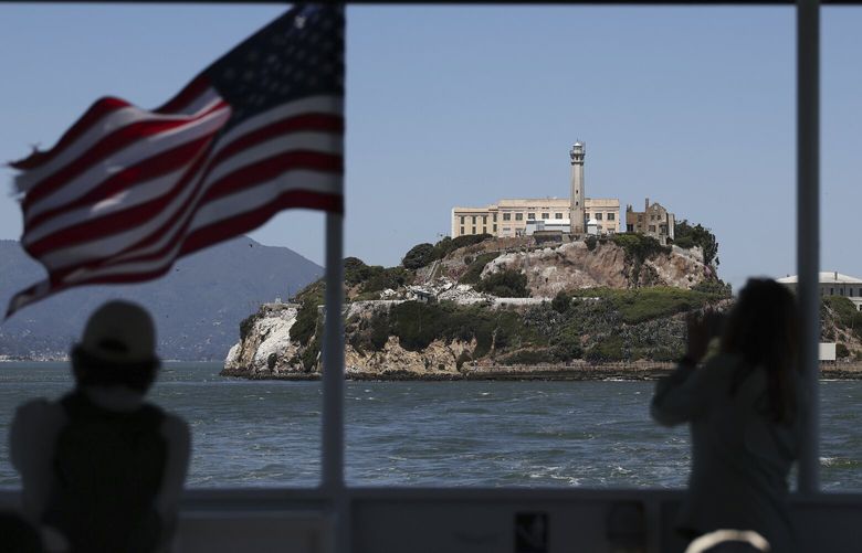 People take photos of Alcatraz Island from a ferry in San Francisco, Monday, May 5, 2025. (AP Photo/Jed Jacobsohn) CAJJ152 CAJJ152