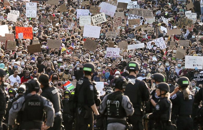 A sea of peaceful protesters are kept back from the Seattle Police Department’s East Precinct on Capitol Hill, by a two-block buffer of officers and gates, seen in the foreground, Monday, June 1, 2020 in Seattle, as demonstrations continues, sparked by the death of George Floyd in Minneapolis. The view is looking west on E. Pine St. from 13th Ave. 214121 214121