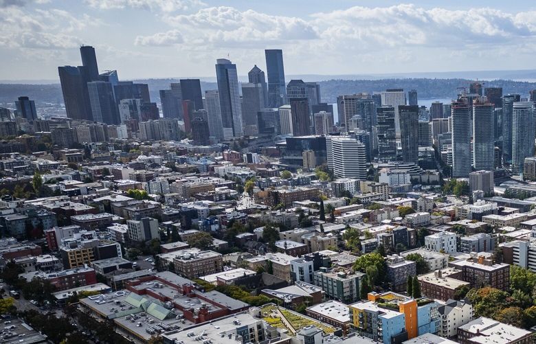 Capitol Hill apartments spread out as far as the eye can see, with downtown Seattle and Puget Sound in the background, seen from the air, Wednesday, Oct. 2, 2024. (Ken Lambert / The Seattle Times)