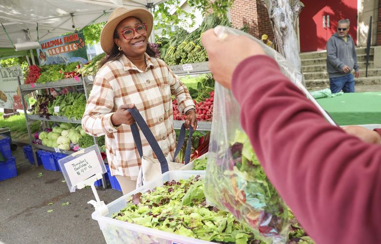 Quianna Ross shops for fresh produce from the Mariposa Farm booth at the Columbia City Farmers Market in Seattle on Wednesday, May 7, 2025. 230045