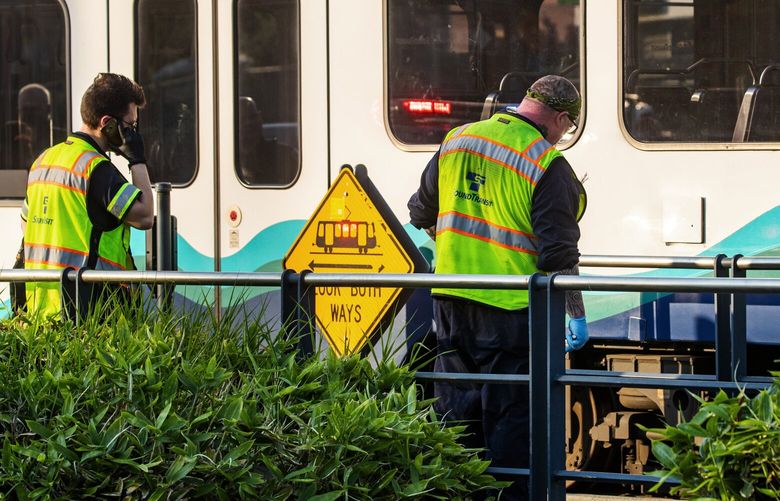 Sound Transit employees inspect a train after it hit and killed two people crossing the street at Martin Luther King Way South and South Alaska Street near the Columbia City station Friday evening, July 2, 2021. 217560