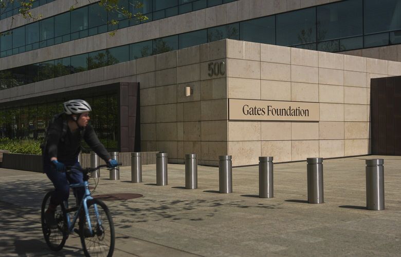 A bicyclist rides by the Gates Foundation campus Wednesday, April 30, 2025, in Seattle. (AP Photo/Lindsey Wasson) WALW818 WALW818