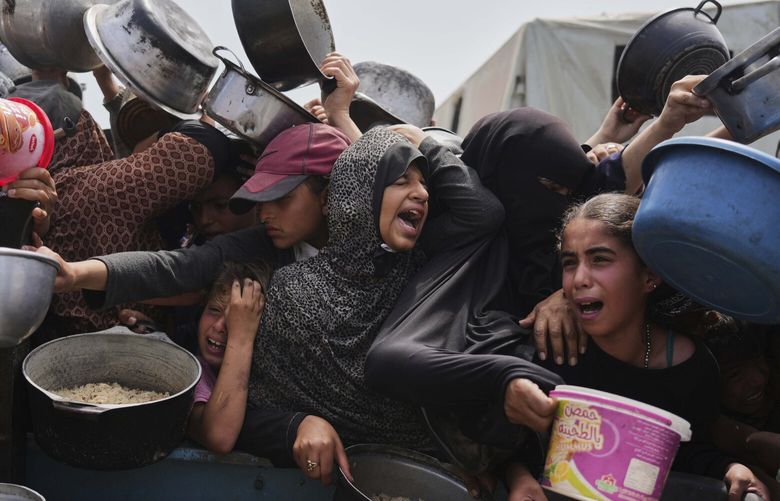 Palestinian children receive donated food at a distribution center in Khan Younis, Gaza Strip, April 21, 2025. (Abdel Kareem Hana / AP)