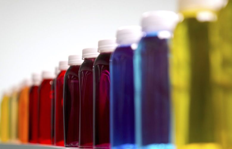 FILE – Bottles containing a variety of colored liquids sit on a shelf in a lab at Sensient Technologies Corp., a color additive manufacturing company, in St. Louis., on Wednesday, April 2, 2025. (AP Photo/Jeff Roberson, File) ny306 ny306