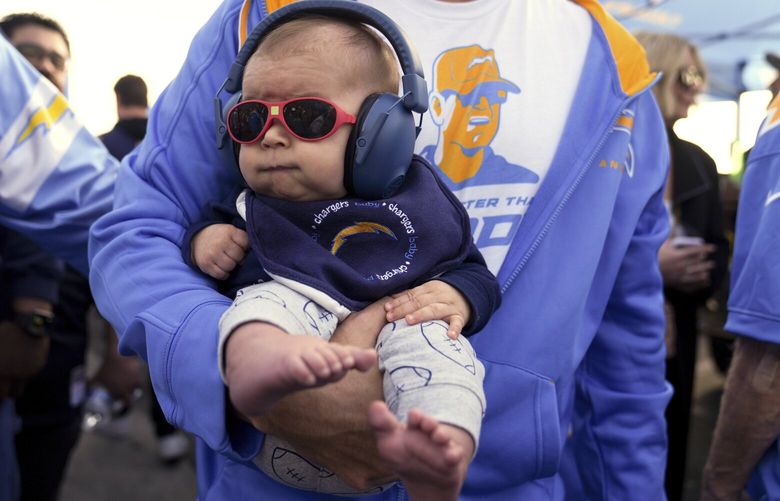 FILE – A baby is carried in the tailgating section before an NFL football game, Nov. 25, 2024, in Inglewood, Calif. (AP Photo/Eric Thayer, File) WX507 WX507