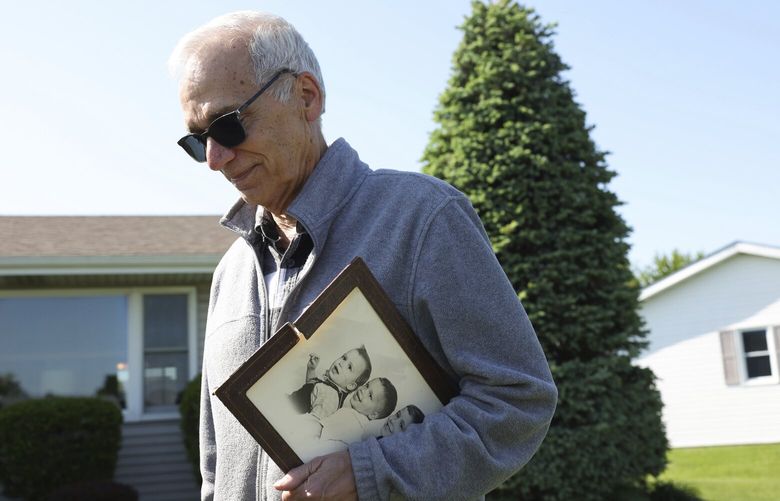 John Prevost, brother of new Pope Leo XIV, holds a portrait of the three Prevost brothers from 1958 while answering reporters’ questions outside his home Thursday, May 8, 2025, in New Lenox, Ill. (John J. Kim/Chicago Tribune via AP) ILCHT401 ILCHT401