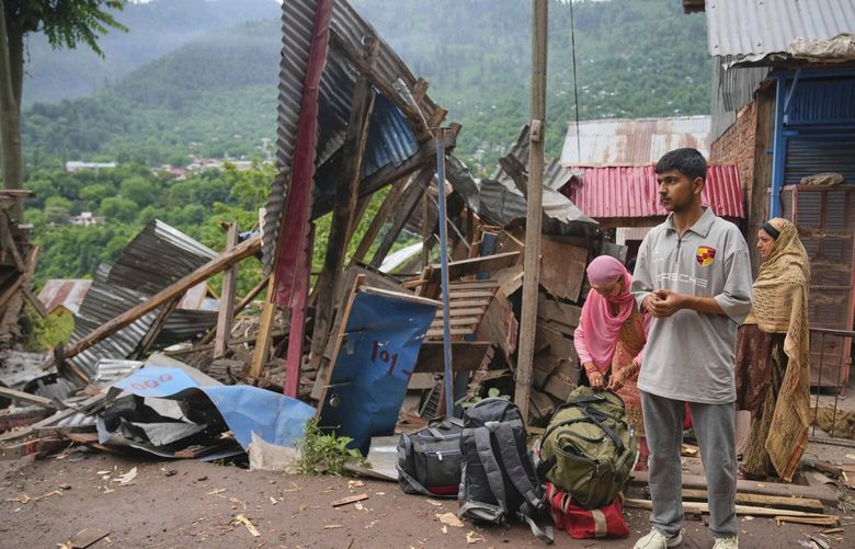 A family waits for transportation as they leave following overnight shelling from Pakistan at Gingal village in Uri district, Indian controlled Kashmir, Friday, May 9, 2025. (AP Photo/Dar Yasin) DYX108 DYX108
