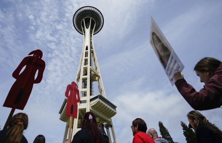 Marchers walk past the Space Needle during the third annual march and gathering for Missing & Murdered Indigenous Women, People & Families, hosted by the grassroots organization MMIWP Families, Saturday, May 6, 2023, in Seattle. (AP Photo/Lindsey Wasson) WALW124