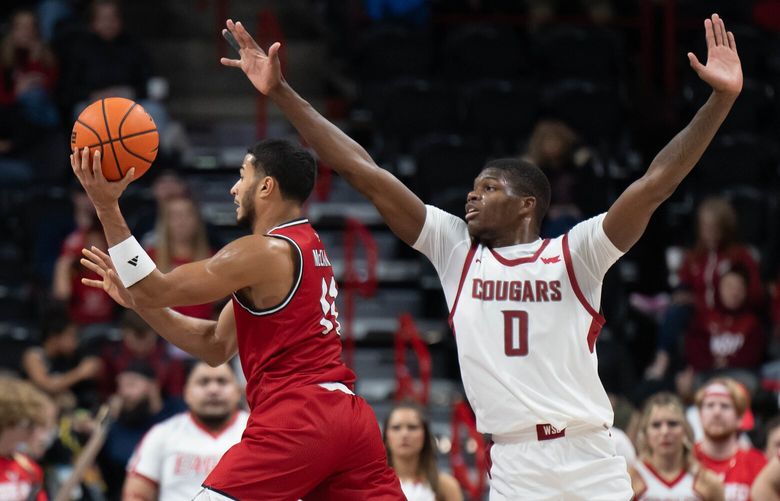Eastern Washington guard Nic McClain (11) makes a pass as Washington State guard Cedric Coward (0) defends during the second half of a NCAA college basketball game, Thursday, Nov. 21, 2024, at the Spokane Veterans Arena.