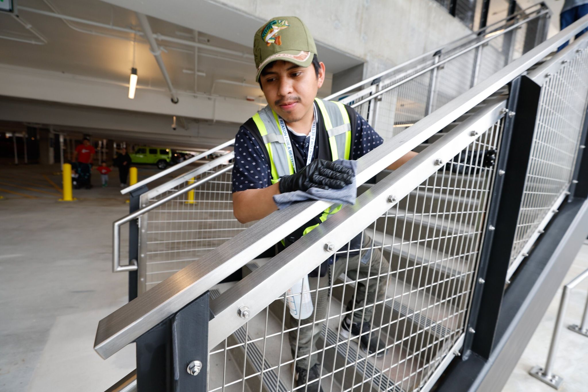 Джонатан Линдо Яо из Dexterra, подрядчика Sound Transit, очищает поручни на станции Marymoor Village в день открытия продления линии Sound Transit 2. (Карен Дюси / The Seattle Times)