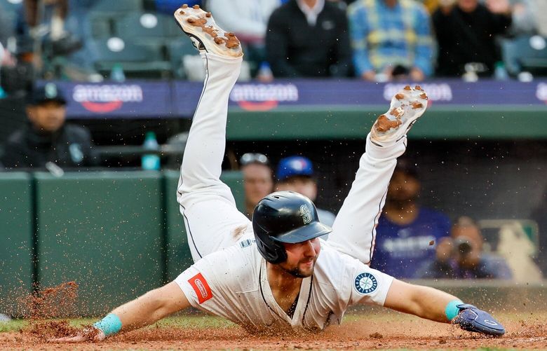 Seattle Mariners catcher Cal Raleigh comes sliding safely into home plate for a run during the fourth inning Saturday, May 10, 2025 in Seattle. 230026