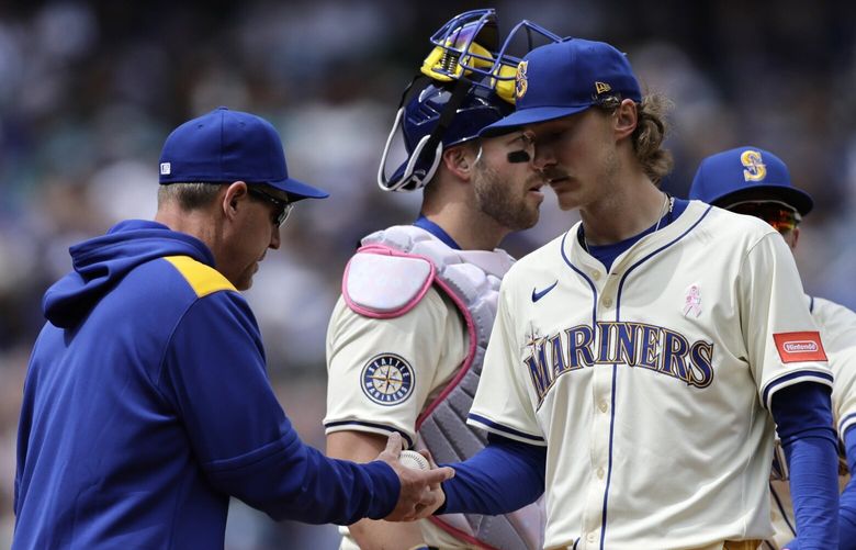 Seattle Mariners starting pitcher Bryce Miller, front right, hands the ball to manager Dan Wilson, left, as he exits during the sixth inning of a baseball game against the Toronto Blue Jays, Sunday, May 11, 2025, in Seattle. (AP Photo/John Froschauer) WAJF116 WAJF116