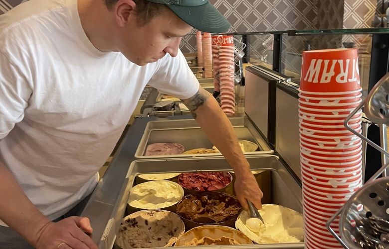 FILE – Salt & Straw Ice Cream Co-Founder Tyler Malek scoops “Day-Old Bread Pudding” upcycled ice cream in Los Gatos, Calif., on June 2, 2023.  (AP Photo/Haven Daley, File) NYCL111 NYCL111